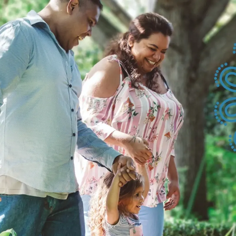 Aboriginal couple walking with their young daughter outdoors