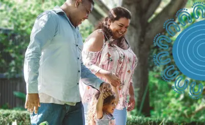 Aboriginal couple walking with their young daughter outdoors