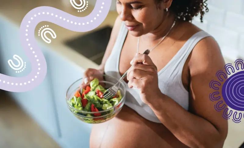 Pregnant Aboriginal woman eating a fresh salad